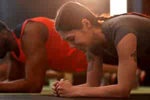 Gratis foto zijaanzicht mensen trainen samen in de sportschool