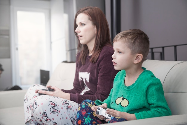 Zijaanzicht moeder en zoon spelen van videogames