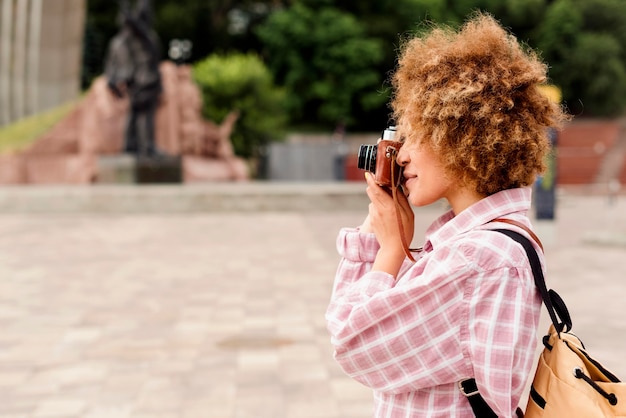 Gratis foto zijaanzicht mooie vrouw die een foto met kopie ruimte neemt