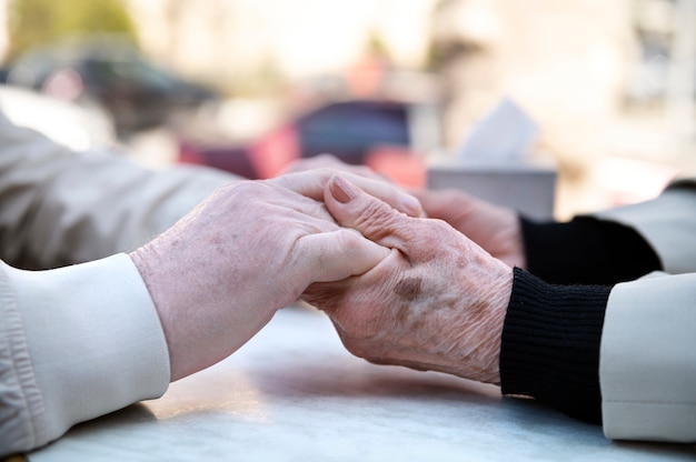 Zijaanzicht oude mensen hand in hand