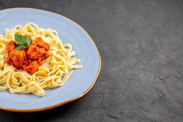 Zijaanzicht pasta met vlees aan de linkerkant van de tafel pasta met vlees en jus