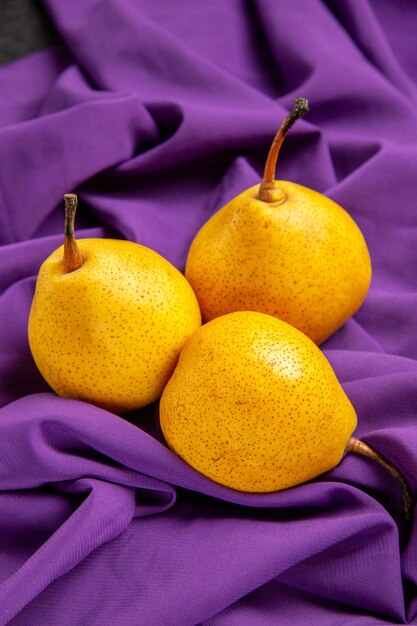 Zijaanzicht peren op tafel drie peren op het tafelkleed op tafel