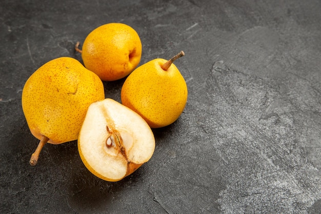 Zijaanzicht smakelijke peren smakelijke peren en een halve peer op het donkere oppervlak