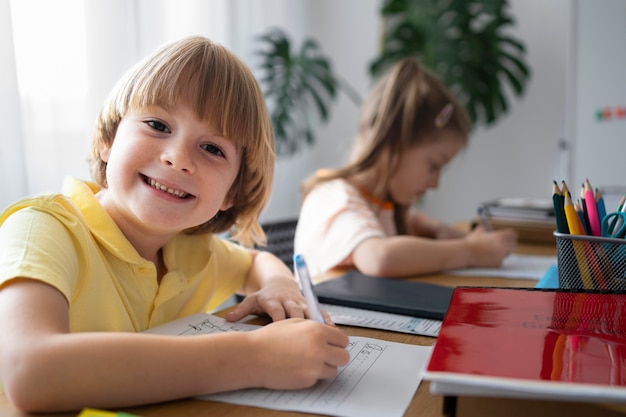 Zijaanzicht smiley jongen schrijven op papier