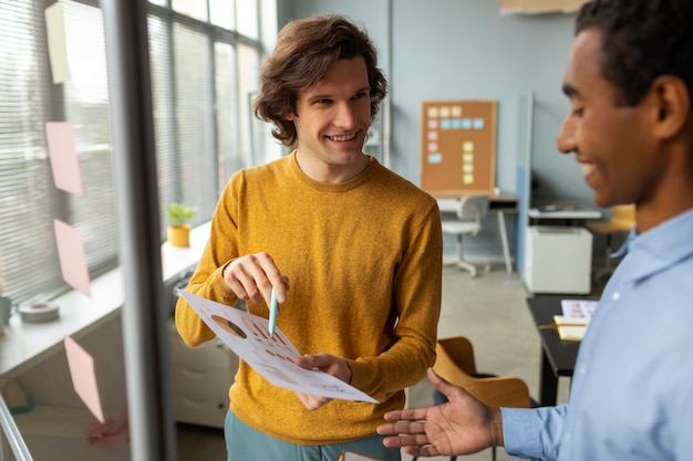 Gratis foto zijaanzicht smiley mannen werken samen