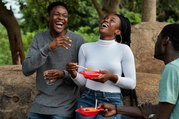 Gratis foto zijaanzicht smiley mensen lunchen buiten