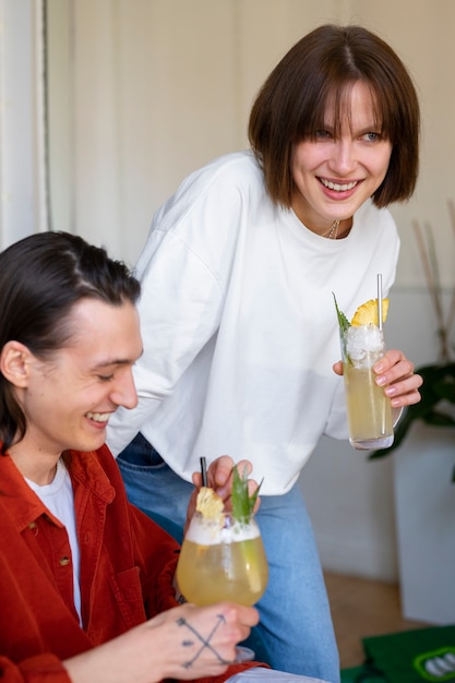 Gratis foto zijaanzicht smiley mensen met cocktails