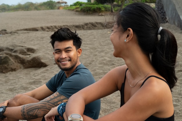 Zijaanzicht smiley mensen zitten op het strand