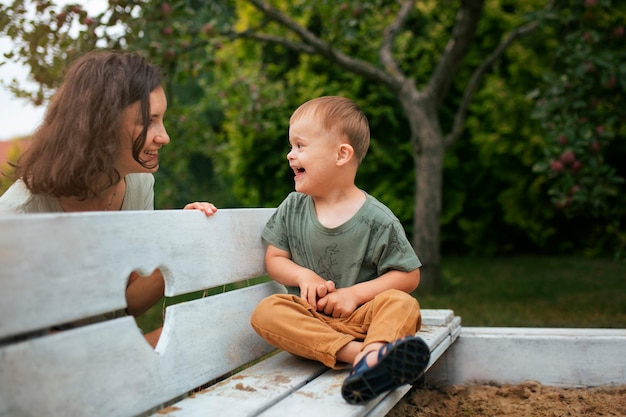 Gratis foto zijaanzicht smiley moeder kijkt naar kind