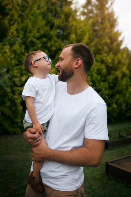 Gratis foto zijaanzicht smiley vader die kind vasthoudt