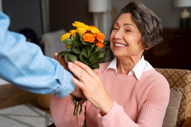 Zijaanzicht smiley vrouw die bloemen ontvangt