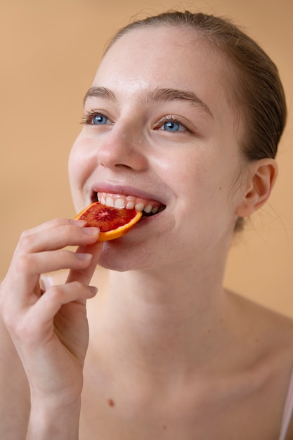 Gratis foto zijaanzicht smiley vrouw die fruit eet