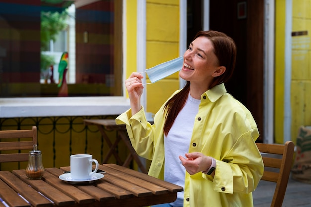 Gratis foto zijaanzicht smiley vrouw die masker afdoet