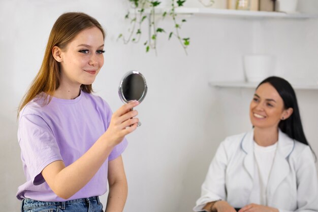 Zijaanzicht smiley vrouw in de spiegel kijken