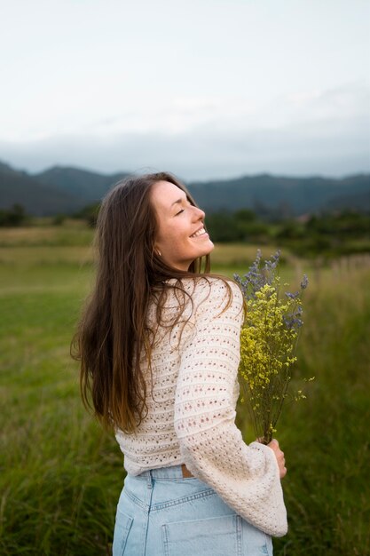 Zijaanzicht smiley vrouw met bloemen