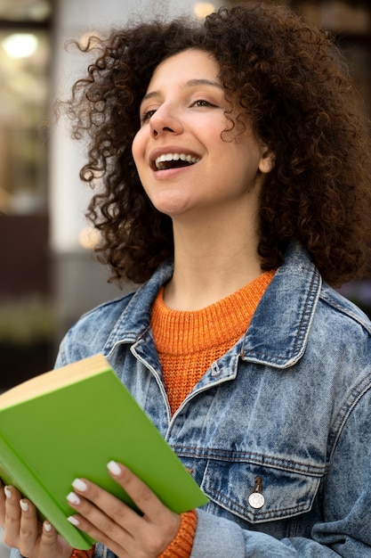 Zijaanzicht smiley vrouw met boek