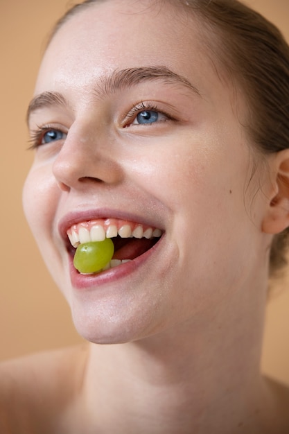 Gratis foto zijaanzicht smiley vrouw met druif