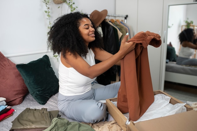 Gratis foto zijaanzicht smiley vrouw met kleren