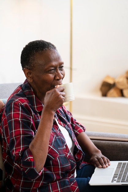 Gratis foto zijaanzicht smiley vrouw met laptop aan het werk