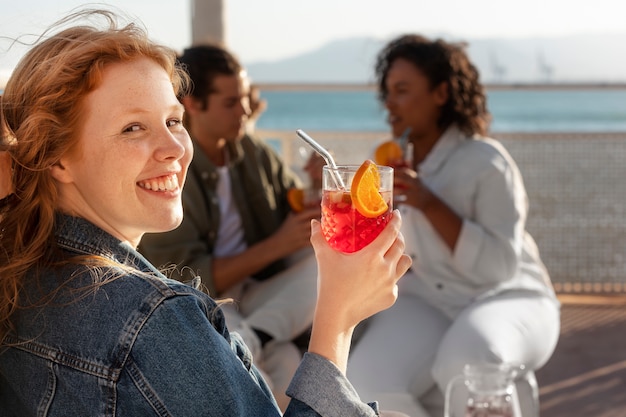 Zijaanzicht smiley vrouw met sangria