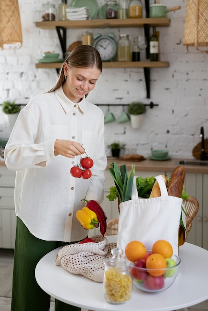 Gratis foto zijaanzicht smiley vrouw met tomaten