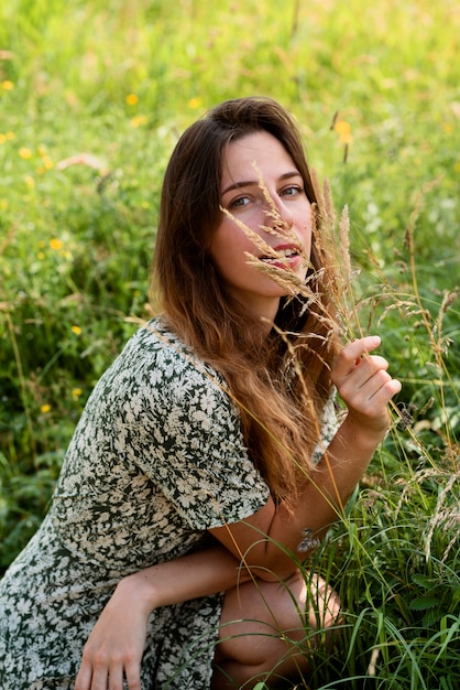 Zijaanzicht smiley vrouw poseren in de natuur