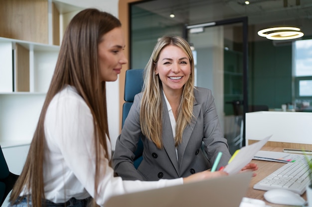 Gratis foto zijaanzicht smiley vrouwen die samenwerken