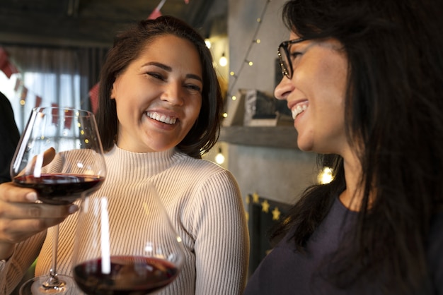 Gratis foto zijaanzicht smiley vrouwen met wijn