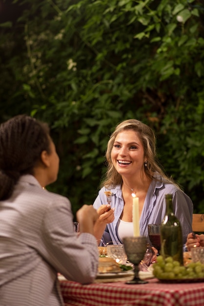 Gratis foto zijaanzicht smiley vrouwen zitten aan tafel