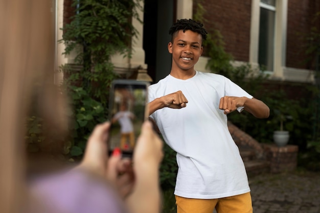 Zijaanzicht smileyjongen die video opneemt