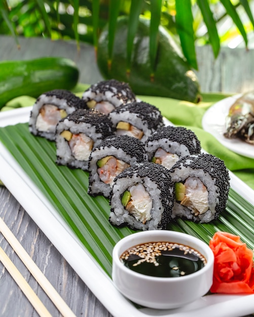 Zijaanzicht sushi rolt met garnalen met gember wasabi en sojasaus op een bord