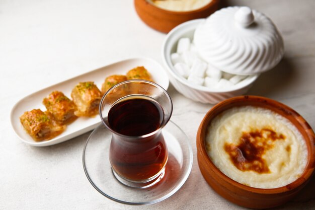 Zijaanzicht thee in een armudu glas met baklava en suiker op tafel