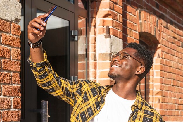 Zijaanzicht tienerjongen die een selfie neemt