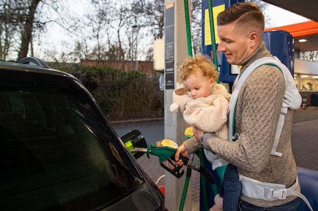 Gratis foto zijaanzicht vader pompend gas