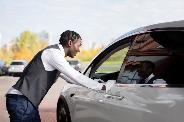 Zijaanzicht valet praten met chauffeur