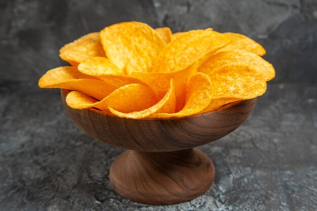 Zijaanzicht van aardappelchips versierd als bloem gevormd in een bruine kom op grijze tafel