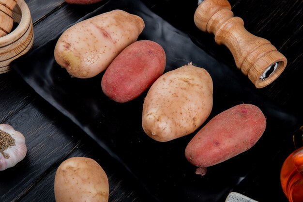 Zijaanzicht van aardappelen in plaat met zout en knoflook op houten tafel