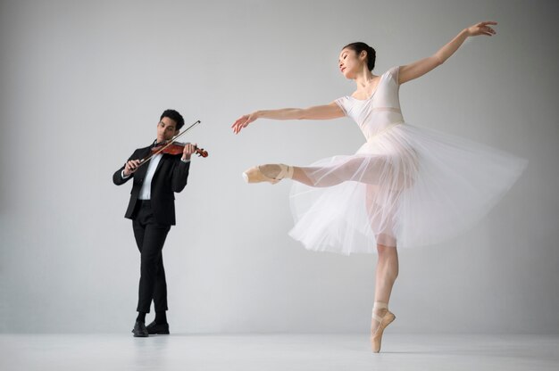 Zijaanzicht van ballerina dansen en viool muzikant