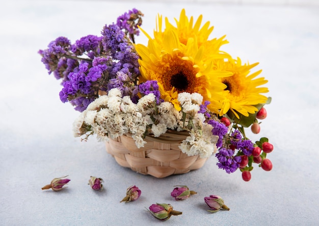 Zijaanzicht van bloemen in de mand op een witte ondergrond