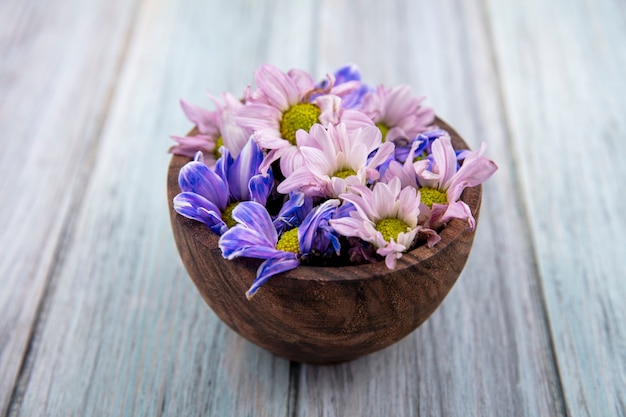 Zijaanzicht van bloemen in kom op houten achtergrond