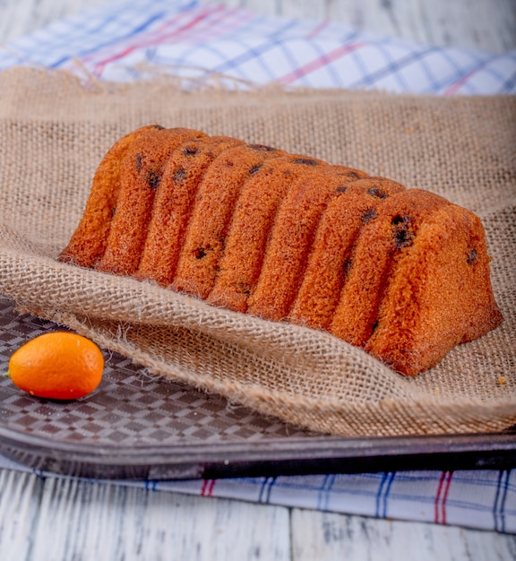 Gratis foto zijaanzicht van cake met rozijnen op rustieke achtergrond