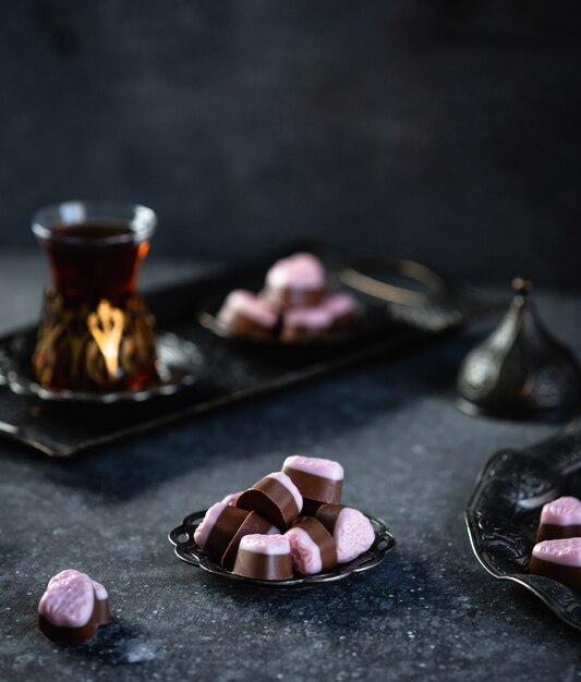 Zijaanzicht van chocolade snoepjes geserveerd met thee op tafel