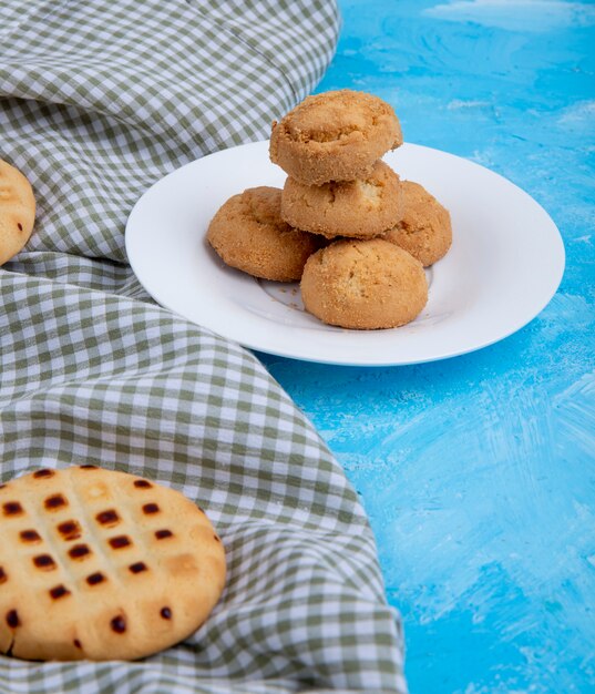 Zijaanzicht van cookies op een witte plaat op blauw