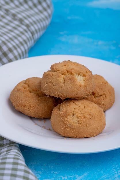 Zijaanzicht van cookies op een witte plaat op blauw