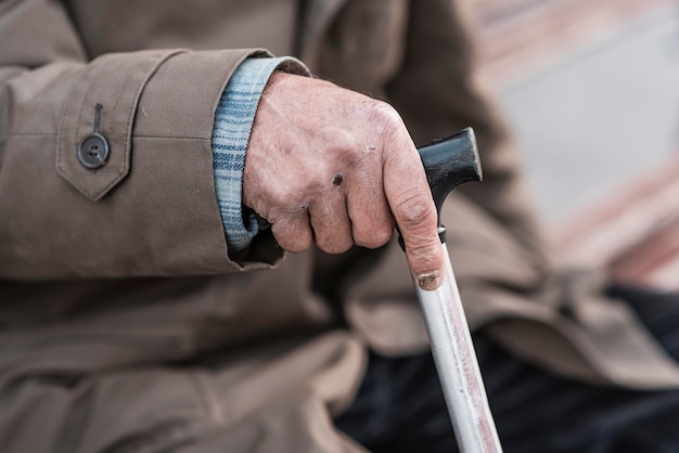 Zijaanzicht van dakloze man met stok