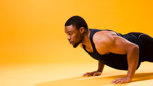 Zijaanzicht van de atletische man doet push-up met kopie ruimte