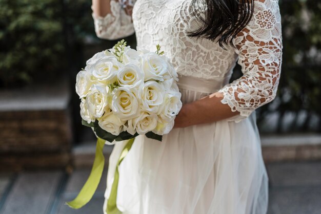 Zijaanzicht van de bruid met boeket bloemen