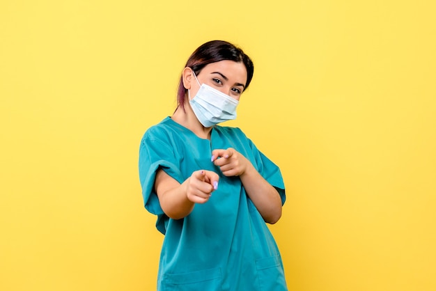 Zijaanzicht van de dokter in een masker moedigt mensen aan om maskers te dragen