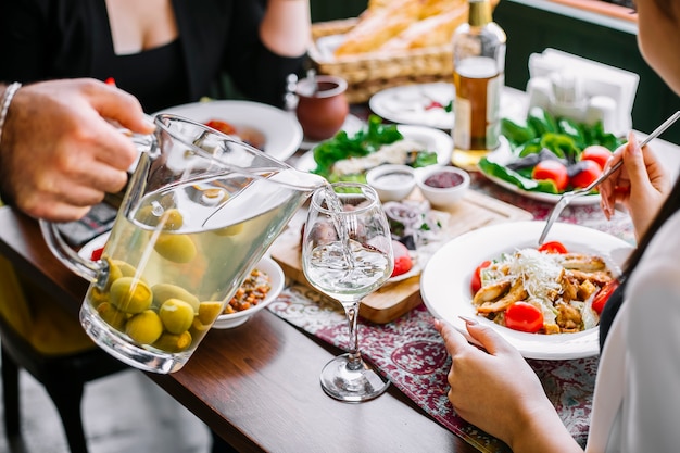 Zijaanzicht van de hand van een man gieten feijoa compote in een glas