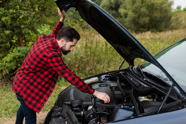 Zijaanzicht van de mens die motor controleert